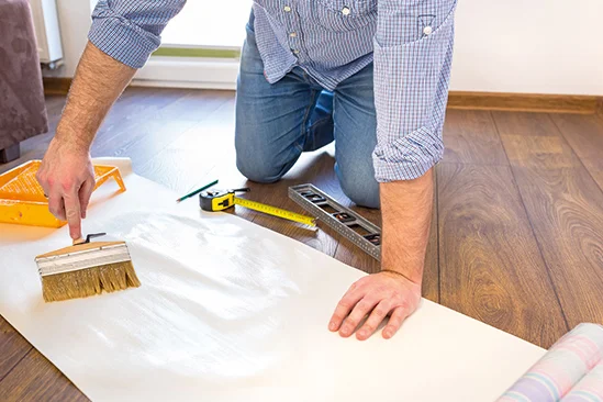 Person trägt Kleister mit Pinsel auf